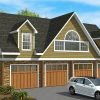 Exterior view of the Cortez kit home featuring four-car garage bays, dormer windows, gable roof, and upper-level loft space with arched window.