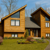 Front exterior view of The Oceanside kit home featuring contemporary rooflines, attached two-car garage, large windows, and optional sundeck.