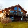 Seahawk kit home with expansive glass front and wraparound deck in wooded setting